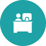 Person at desk with computer icon.